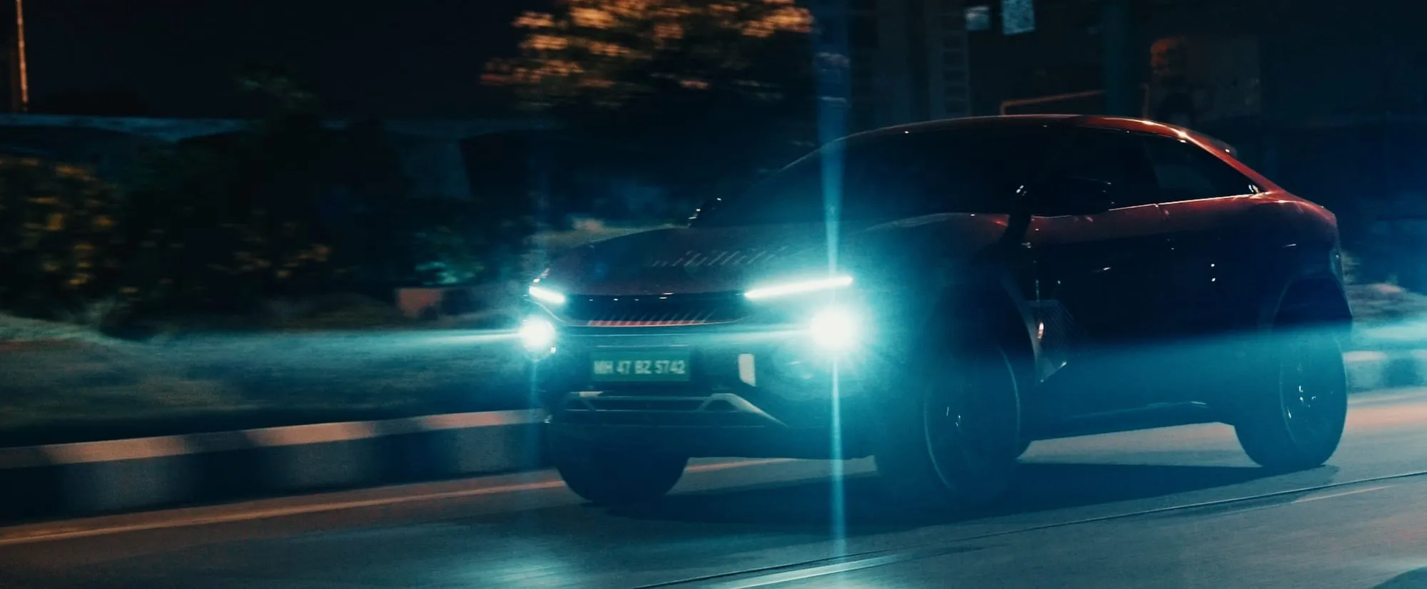 Low angle on the BE 6 as its headlights cut through the dark.