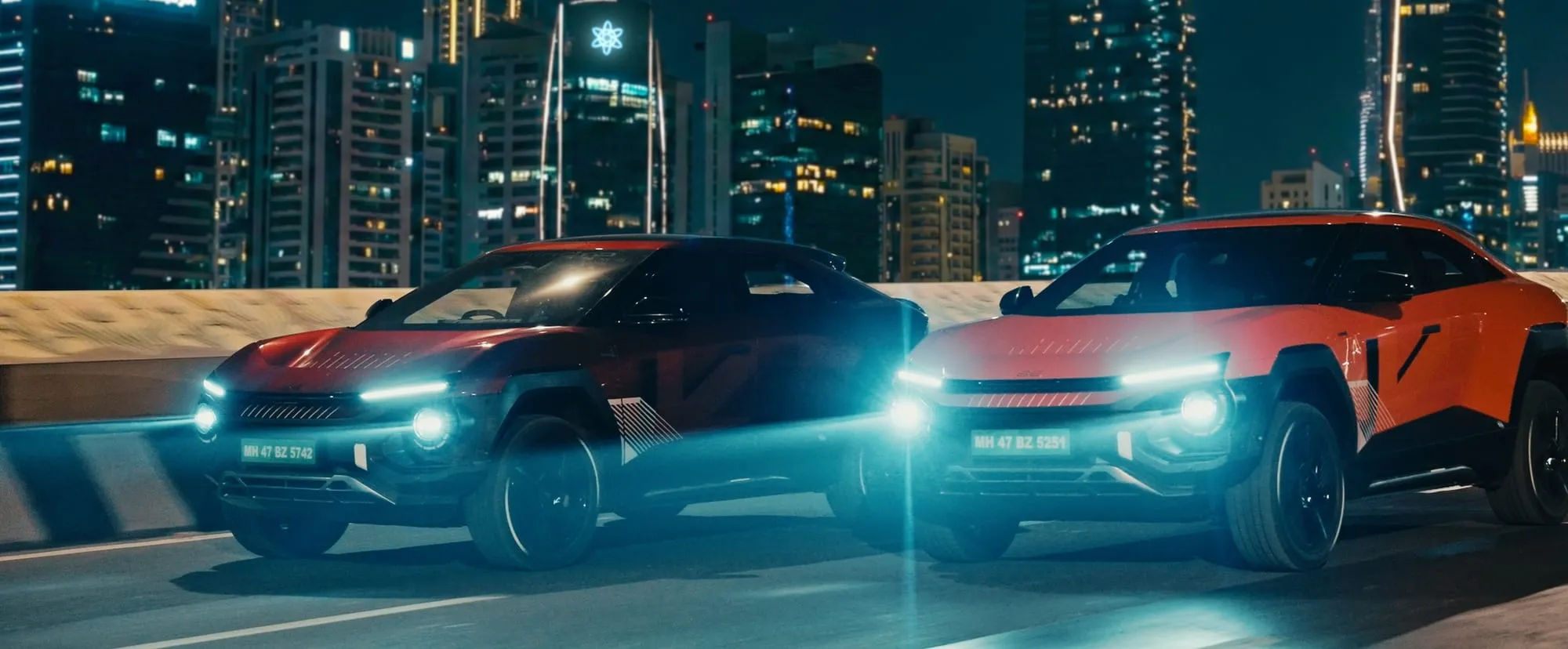 Two BE 6 Formula E Editions against the lit-up city skyline.
